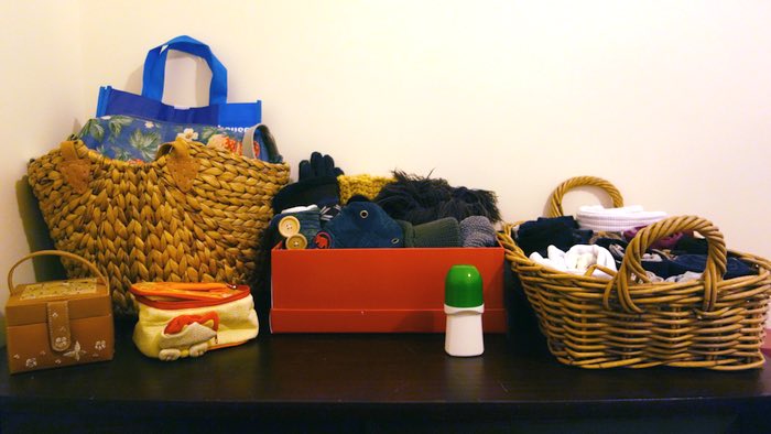 an organised dresser top, holding bags, hats, scarves and socks