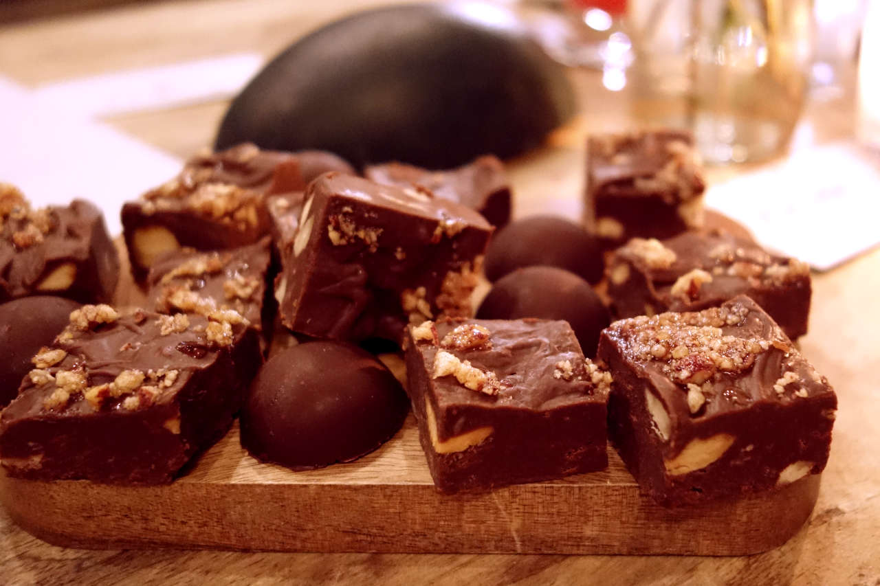 Chocolate truffle and fudge pieces on a wooden board