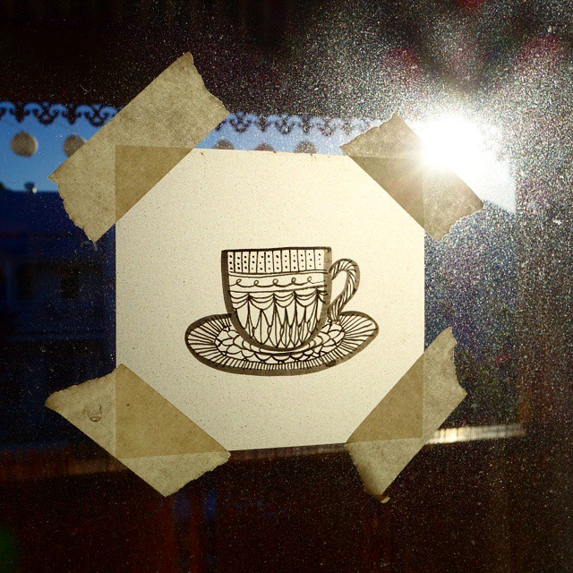 39: Black ink drawing of patterned teacup and saucer on tracing paper, taped to a window