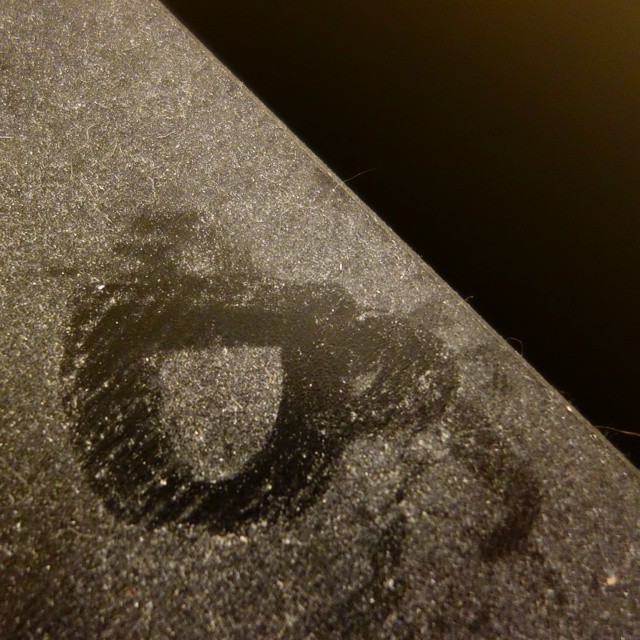41: Finger-drawn teacup in white dust on a black surface