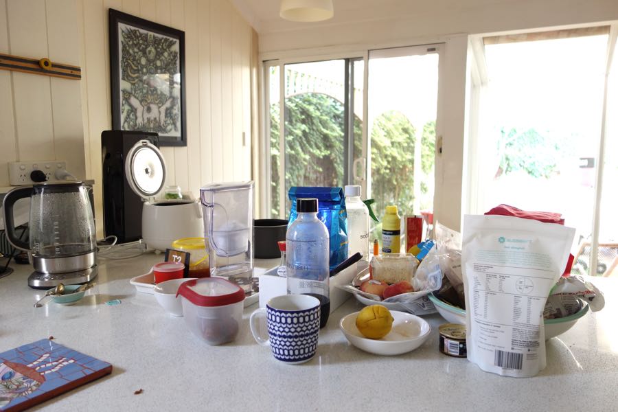 cluttered kitchen bench