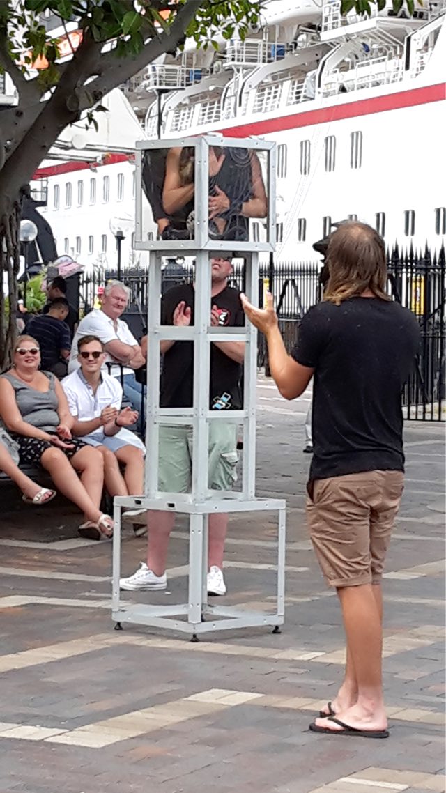 a street performer squeezing herself into a tiny box